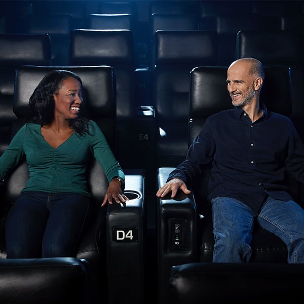 A woman and a man are seated in a movie theater