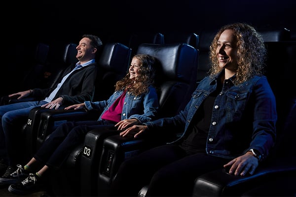 Famille regardant un film dans une salle de cinéma