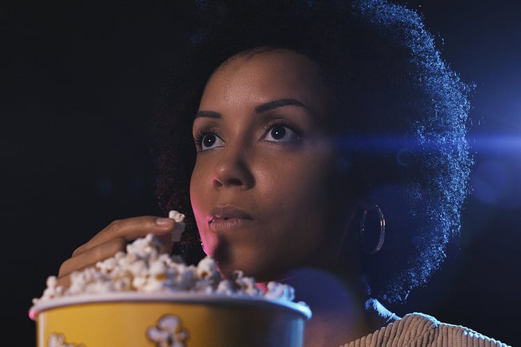 women watching a movie and eating popcorn