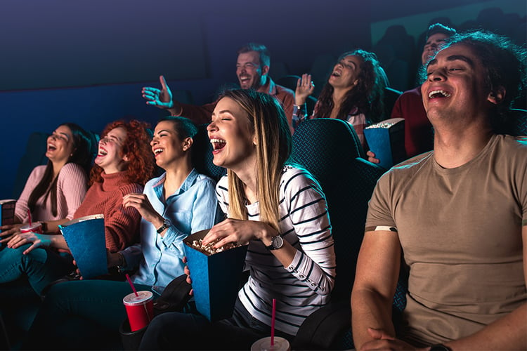 Groupe de jeunes adultes regardant une comédie au cinéma